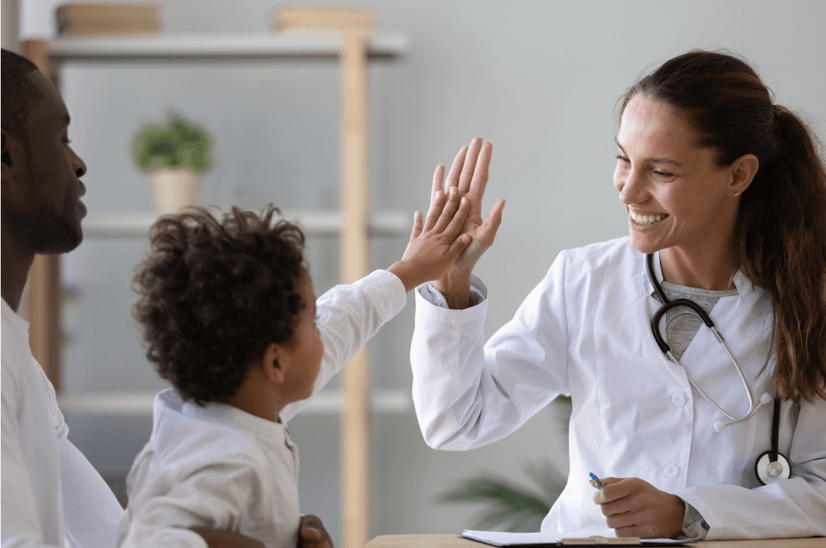 Happy female doctor giving a high-five to a young child
